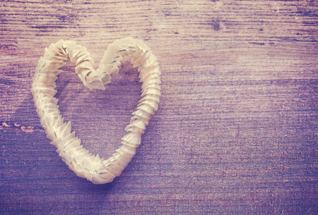 Vintage stylized heart made of shells on wooden background, space for text.の写真素材