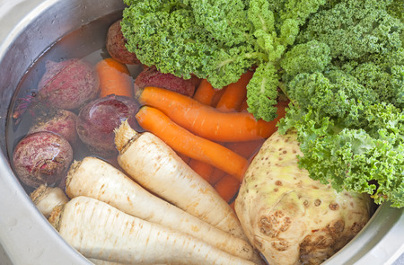 Fresh vegetables washing in a kitchen sink.の写真素材