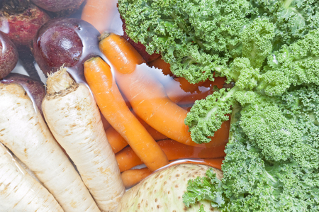 Dirty vegetables in a kitchen sink filled with water.の写真素材