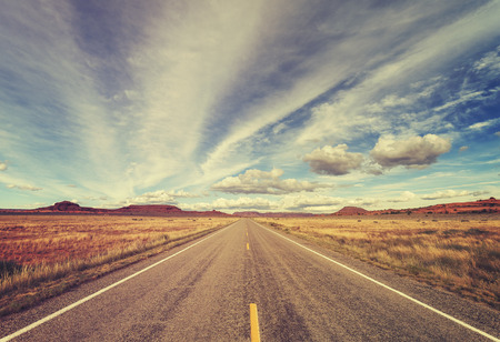 Vintage old film stylized country road, travel concept.の写真素材