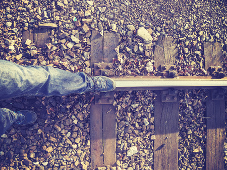 Vintage stylized legs walking on rail track, concept picture.の写真素材