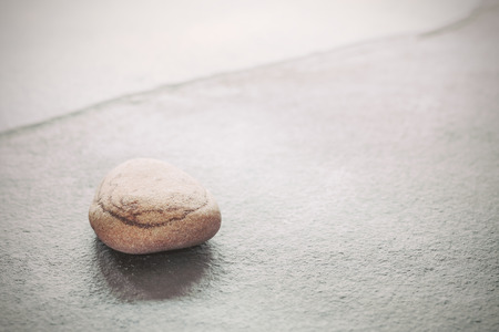 Retro toned stone on a slate, natural background with copy space, shallow depth of field.の写真素材