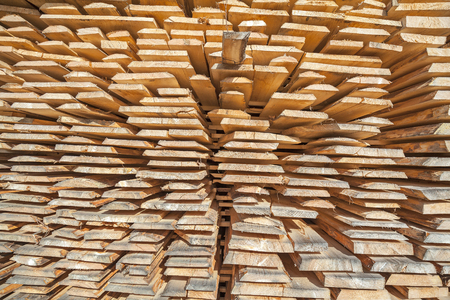 Stack of rough wooden boards in lumberyard.の写真素材