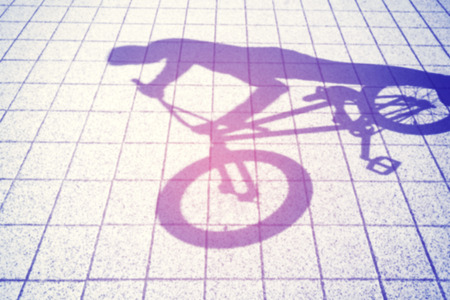 Retro toned blurred shadow of a teenager riding a bmx bike.の写真素材