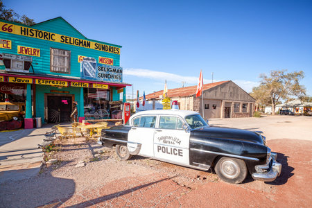 Seligman, USA - September 10, 2015: Old police car in front of historic Sundries Building. The town...