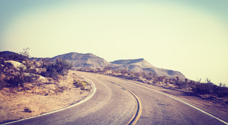 Old film stylized picture of road seen through windshield of a moving car.