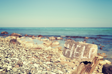 Vintage stylized help word written on an old wooden board, conceptual picture, shallow depth of...