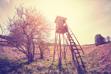 Vintage toned fisheye lens photo of a hunting pulpit at sunset.の写真素材
