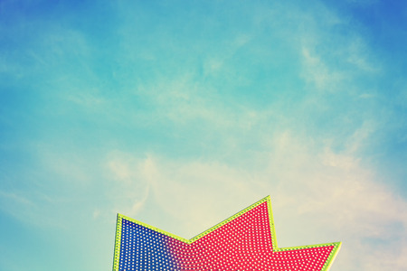Vintage toned star shape board with bulbs against blue sky, abstract background.の写真素材