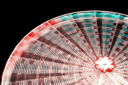 Blurred abstract background made of ferris wheel at night, vintage toned long exposure picture.