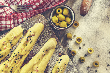 Bread sticks ready for baking, rustic setting on a wooden table.の写真素材