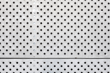 Perforated silver metal surface, industrial background.の写真素材