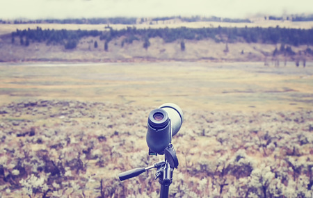 Vintage toned telescope used by wildlife watchers and hunters on a rainy day, selective focus.の写真素材