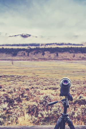 Vintage toned telescope used by wildlife watchers and hunters on a rainy day, selective focus.の写真素材