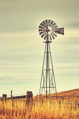 Vintage toned photo of an old western windmill tower, American wild west symbol.の写真素材