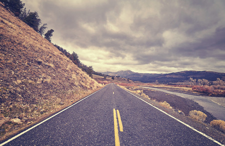 Vintage toned scenic road with stormy clouds, travel concept.の写真素材