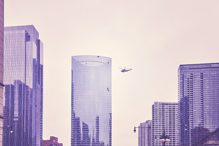 Color toned photo of helicopter flying over Chicago downtown.の写真素材