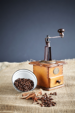 Coffee beans and an old coffee grinder on jute background, selective focus.の写真素材