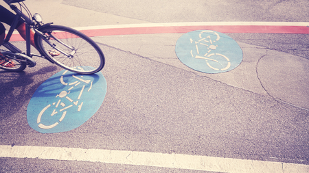 Vintage toned bicycle lane with front part of a bike in motion. 