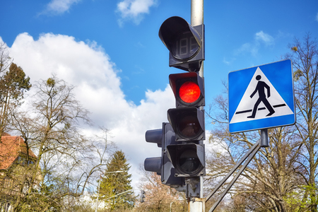 Traffic lights and pedestrian crossing sign in a city.の写真素材
