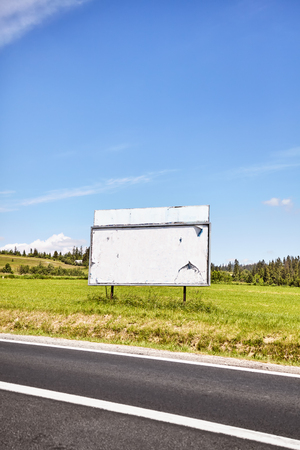 Blank advertising billboard by a road, space for text, shallow depth of field.の写真素材