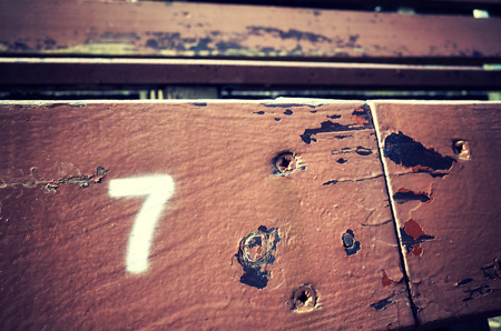 Number seven painted on an old wooden seat, conceptual picture with copy space on the right.の写真素材