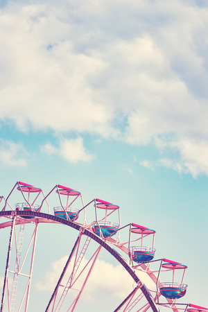 Vintage toned picture of a Ferris wheel against blue sky, space for text.の写真素材