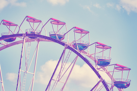 Vintage toned picture of a Ferris wheel against blue sky.の写真素材