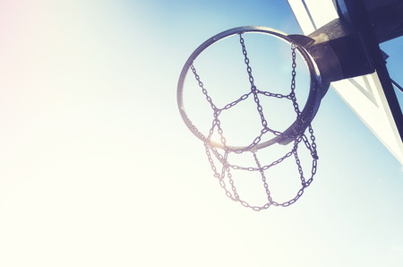 Basketball hoop with chain net at sunset, color toning applied, space for text.の写真素材
