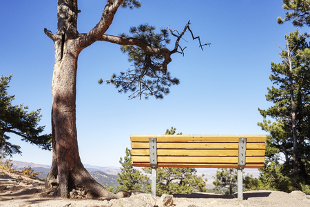 Empty bench on top of a cliff with a mountain view, Colorado, USA.の写真素材
