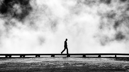 Silhouette of tourist on a footbridge at steamy Grand Prismatic Spring, Yellowstone National Park, Wyoming, USA.の写真素材