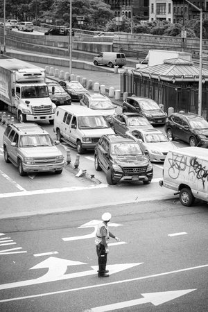New York, USA - May 26, 2017: Police officer stands in the middle of the intersection and regulates traffic in midtown Manhattan.のeditorial素材