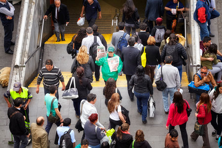 Santiago de Chile, Chile - October 24, 2013: People pass woman advertising La Segunda, Chilean afternoon daily newspaper, at the Plaza de Armas metro station entrance.のeditorial素材