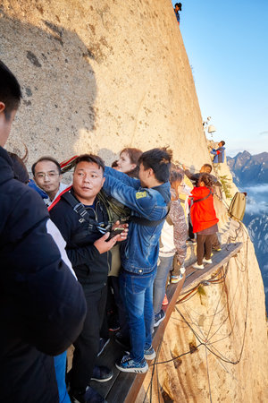Mount Hua, Shaanxi Province, China - October 6, 2017: Tourists queue on the Plank Walk in the Sky, worlds most dangerous hike.のeditorial素材