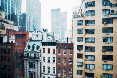 Vintage toned picture of old apartment buildings in Midtown Manhattan on a rainy day, New York, USA.