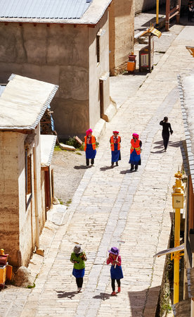 Shangri-La, China - September 25, 2017: Women walk the road in Songzanlin Monastery, built in 1679,...