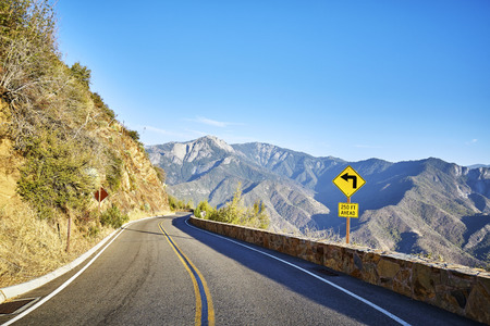 Sharp turn left sign in Yosemite National Park at sunset, California, USA.