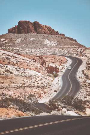 Retro toned picture of a scenic winding road, travel concept, Nevada, USA.の写真素材