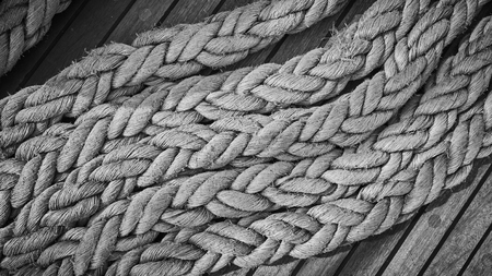 Black and white close up picture ofold frayed boat ropes.