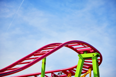 Roller coaster pink tracks in an amusement park, ups and downs concept picture.の写真素材