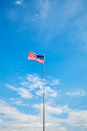 American flag in the blue sky on a sunny day.の写真素材