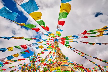 Looking up at Buddhist prayer flags. Tibetans believe the prayers and mantras will be blown by the wind to spread the good will and compassion into space.の写真素材