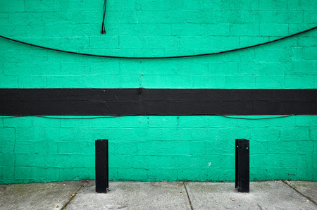 Green painted brick wall with black stripe, abstract urban background, New York City.の写真素材