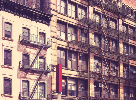 Old buildings with fire escapes in New York City, color toning applied, USA.の写真素材