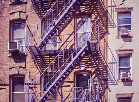 Fire escapes in New York, one of the city symbols, color toned picture, USA.の写真素材