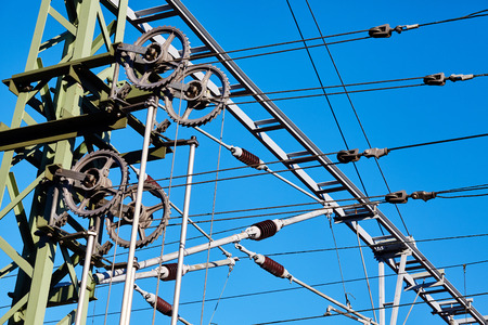 Overhead train electric traction system against the blue sky.の写真素材