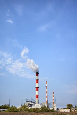 Power plant smoky chimney against the blue sky.の写真素材