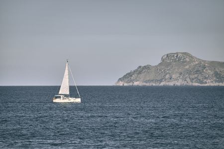 Lonely sailboat at the sea, travel concept, color toned picture.の写真素材