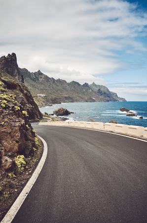 Scenic ocean road by the cliffs of the Macizo de Anaga mountain range, color toning applied, Tenerife, Spain.の写真素材