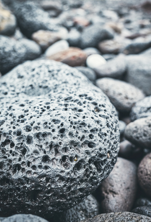 Close up picture of a volcanic rock on a beach, selective focus, color toning applied.の写真素材